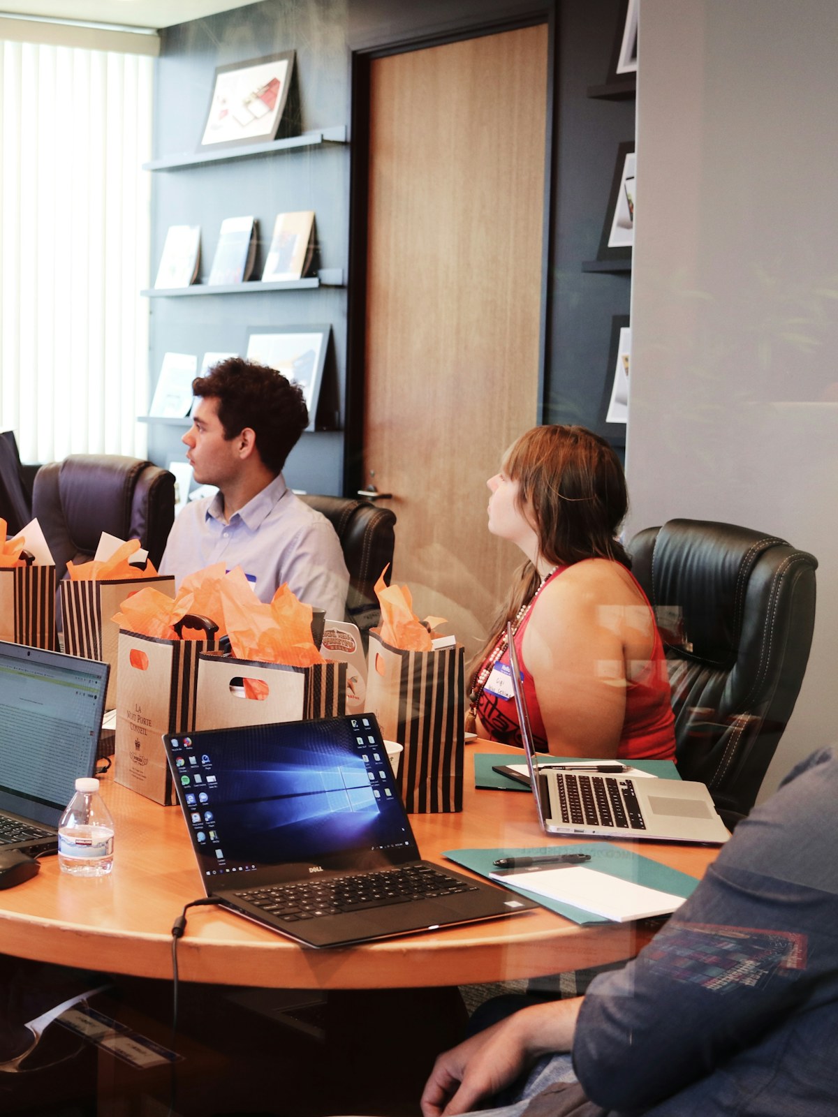 A team reviewing work together in a meeting room, laptops open